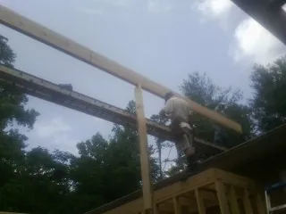 Carpenter setting a ridge beam over a new addition frame — Ice Dam Removal by Roofing Brothers in Wayzata